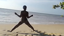 Ebony woman doing some exercise naked on the beach